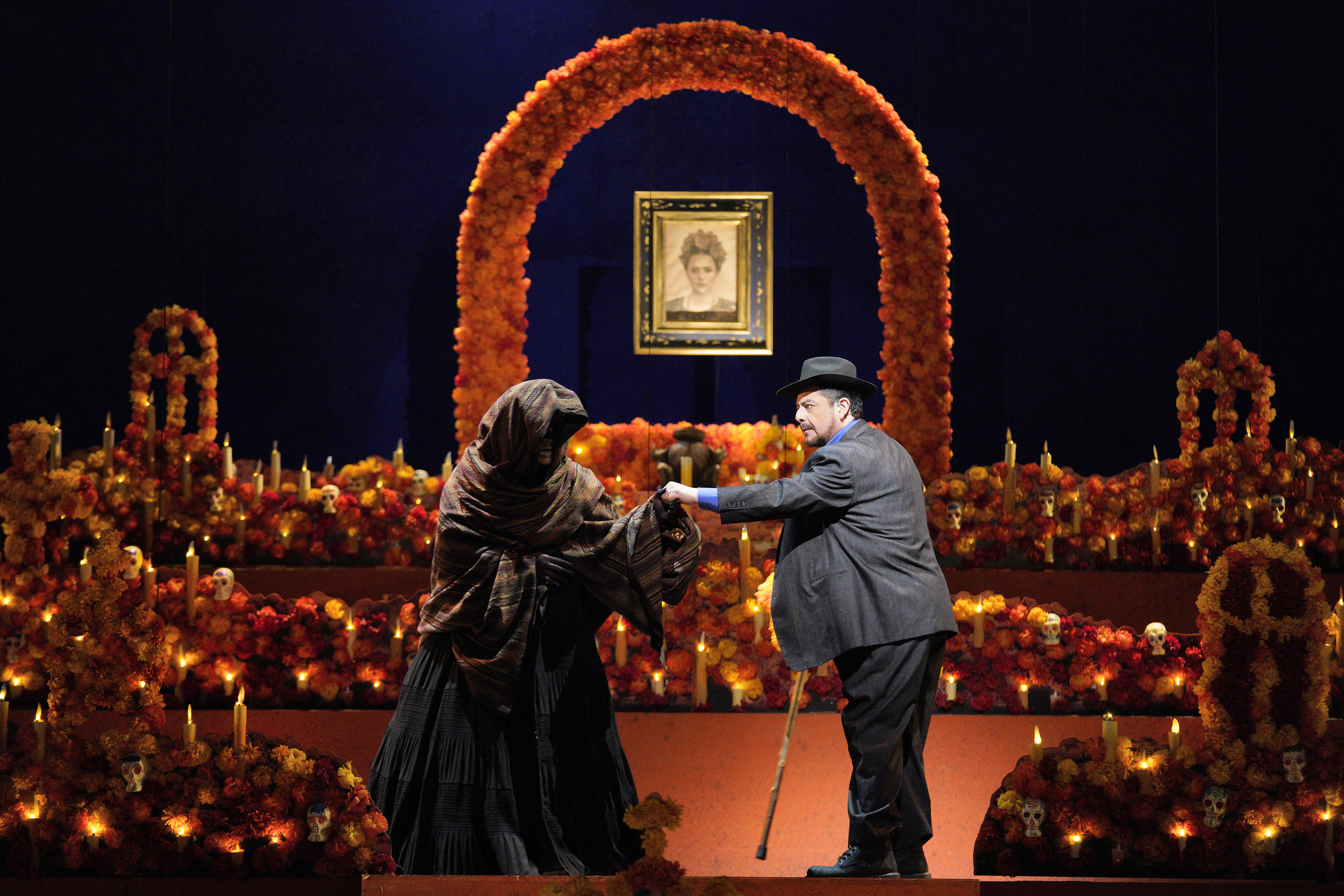 Scene from Frida of a man speaking with a person cloaked in black