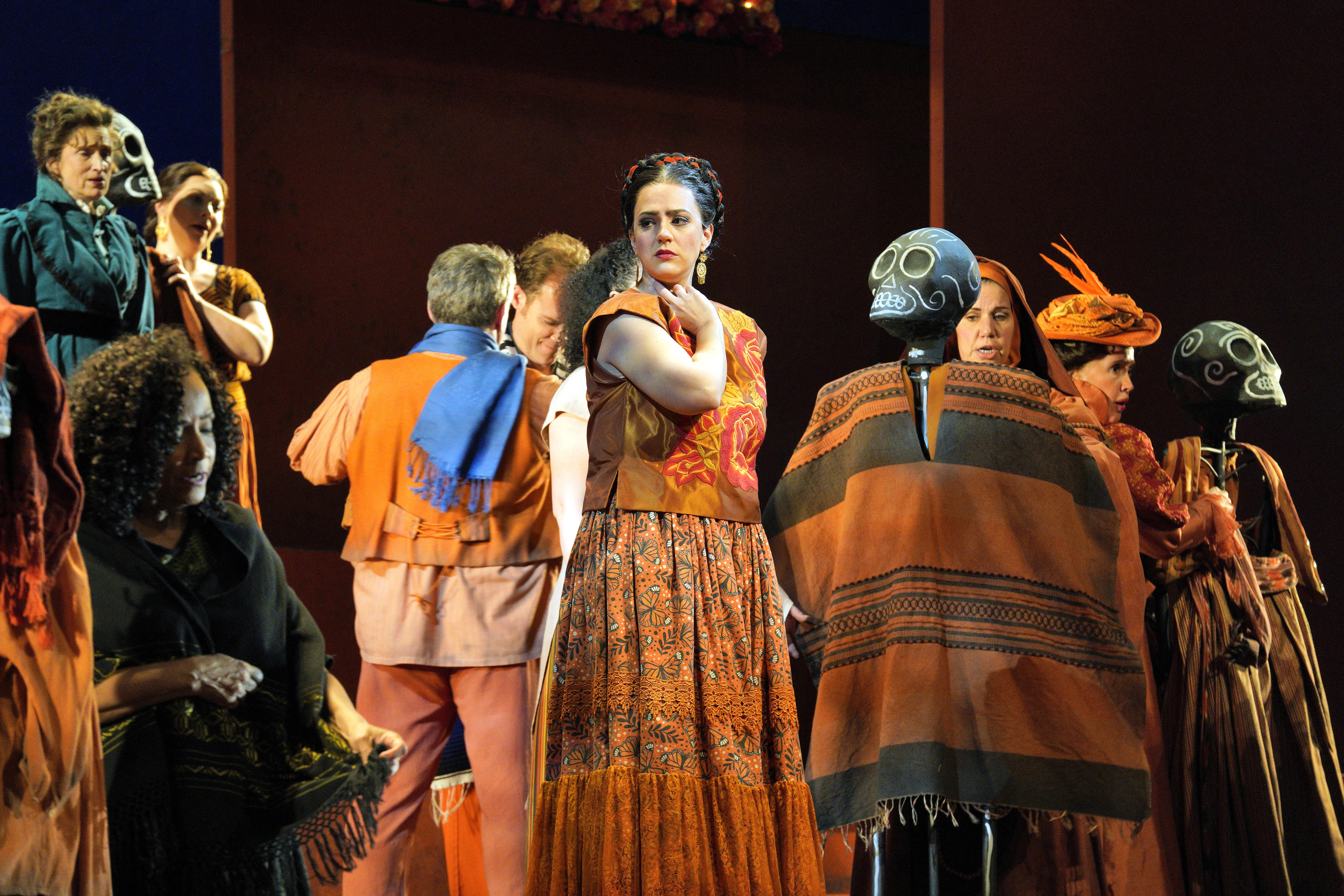 Scene from Frida A group of people dressing up skeletons on stage.