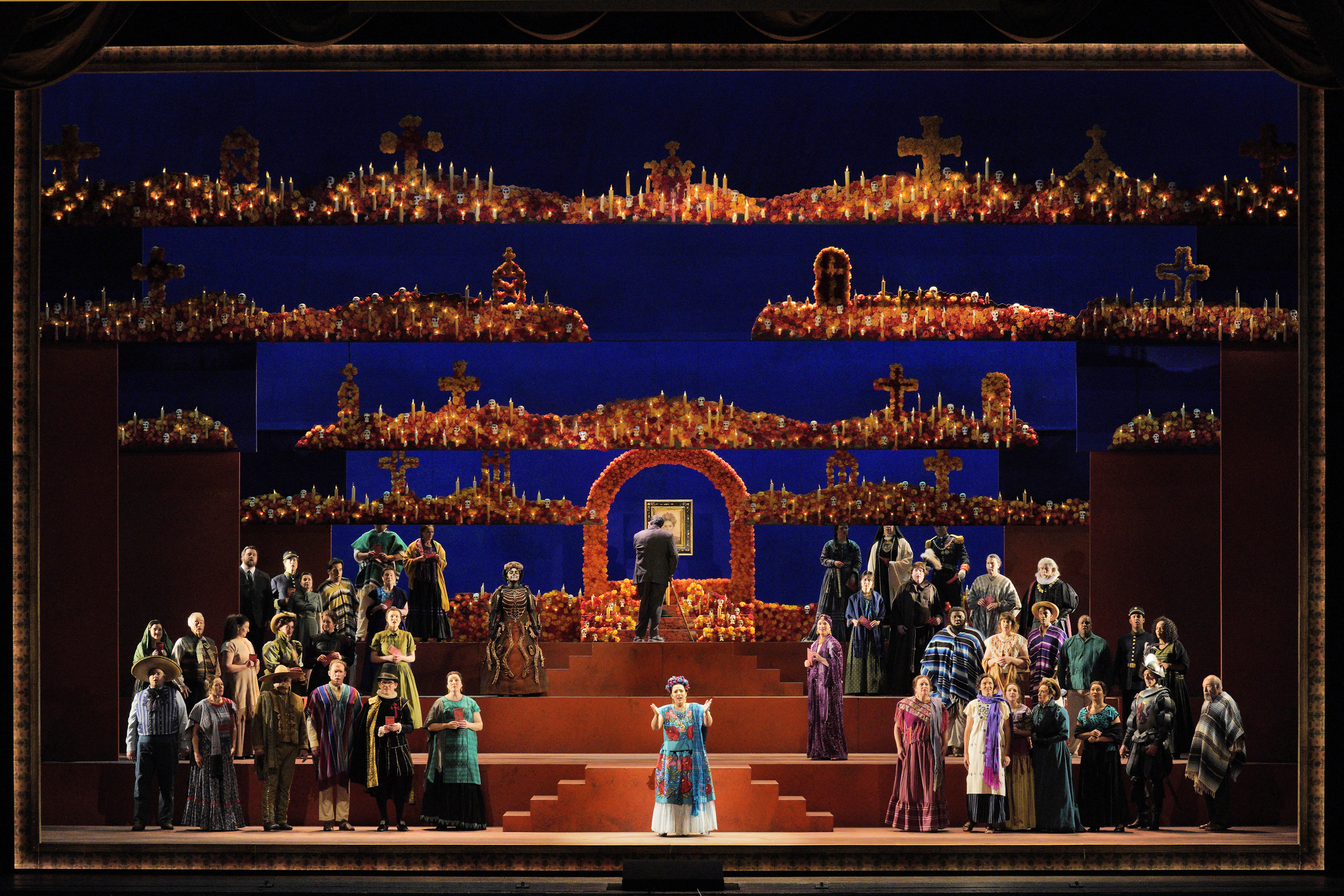 Scene from Frida A group of people standing on stage in front of a large stage.