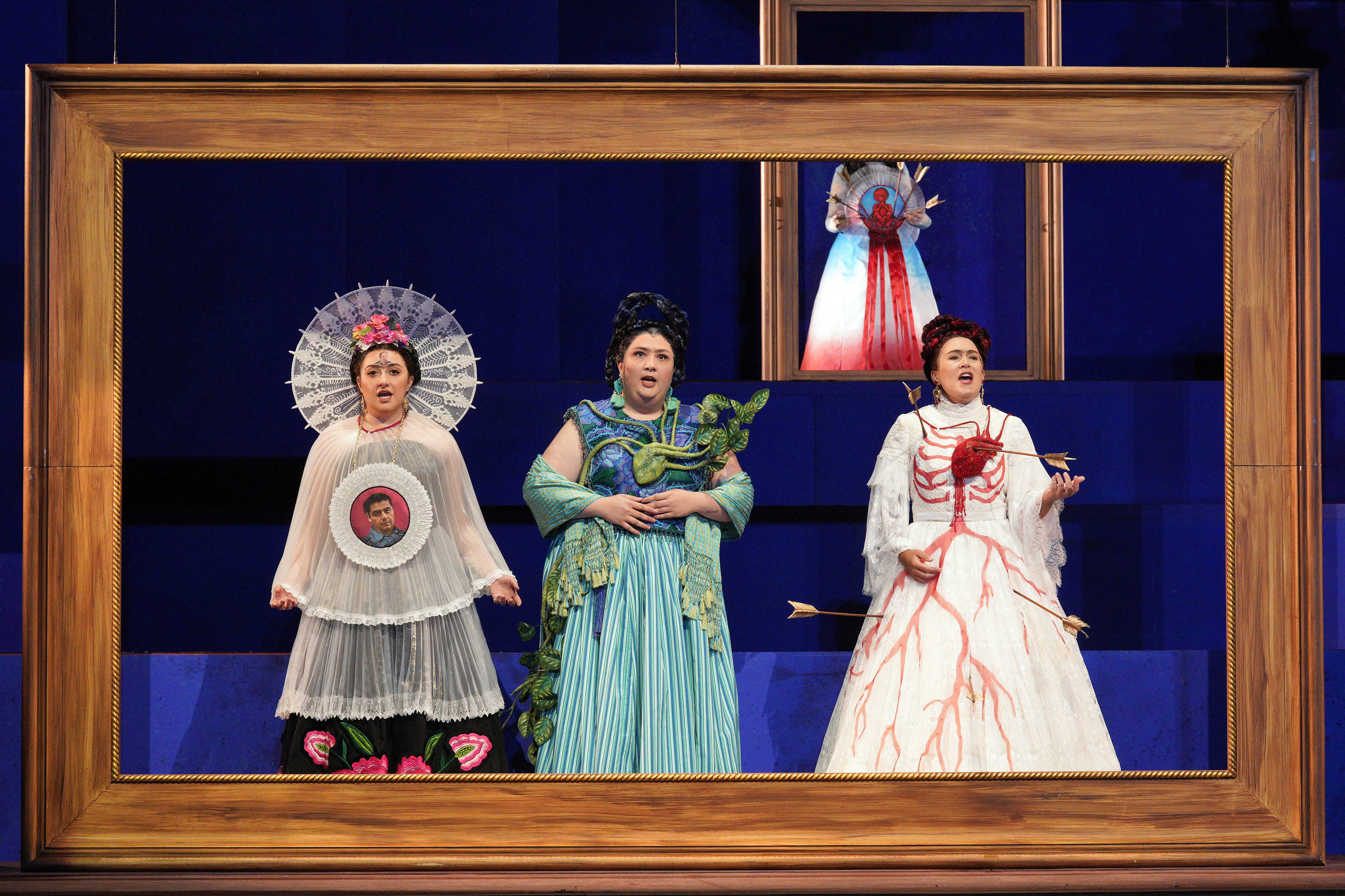 Scene from Frida of three women singing while standing inside a picture frame