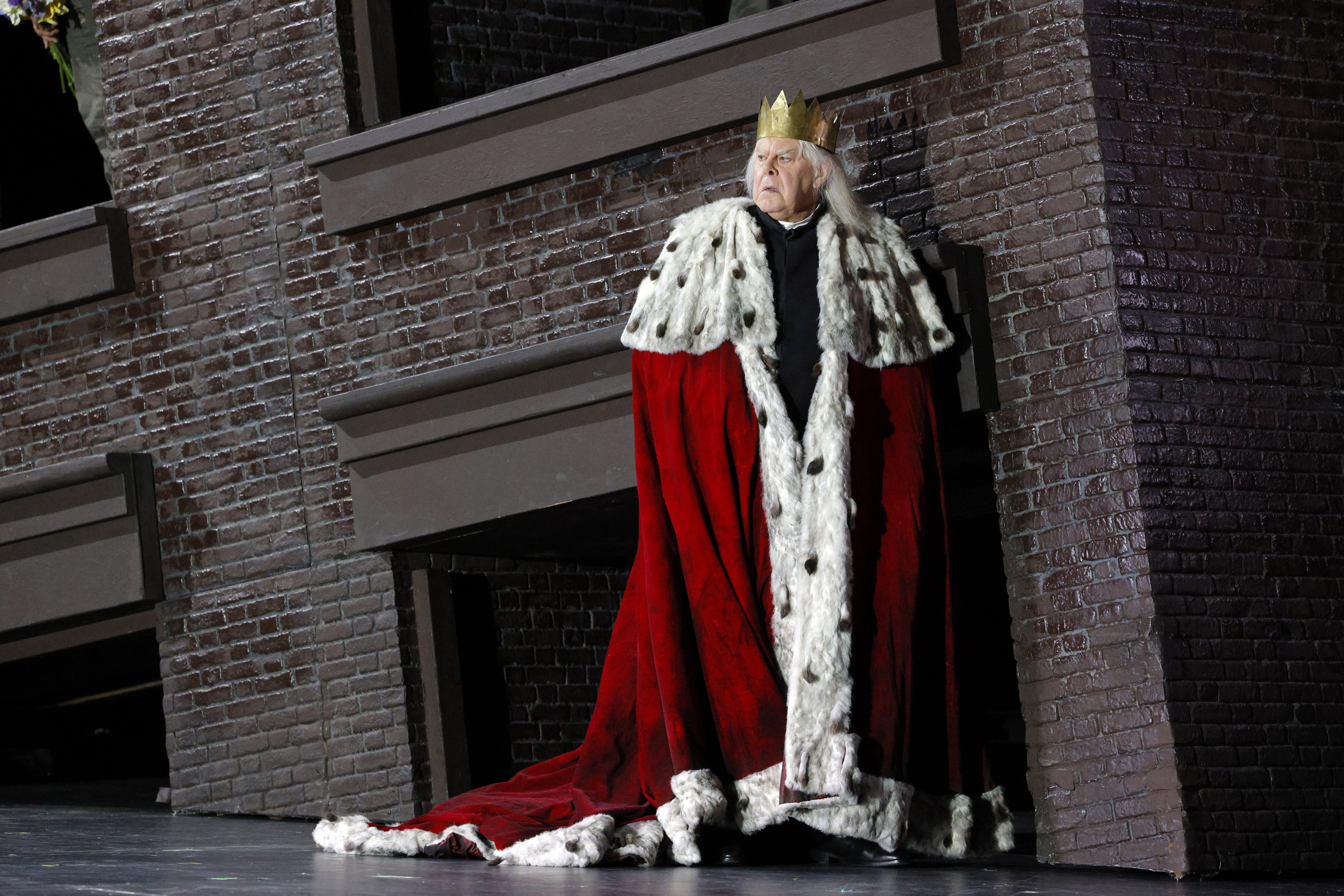 King standing at corner of building